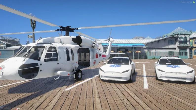 White air ambulance helicopter and two white EMS sedans